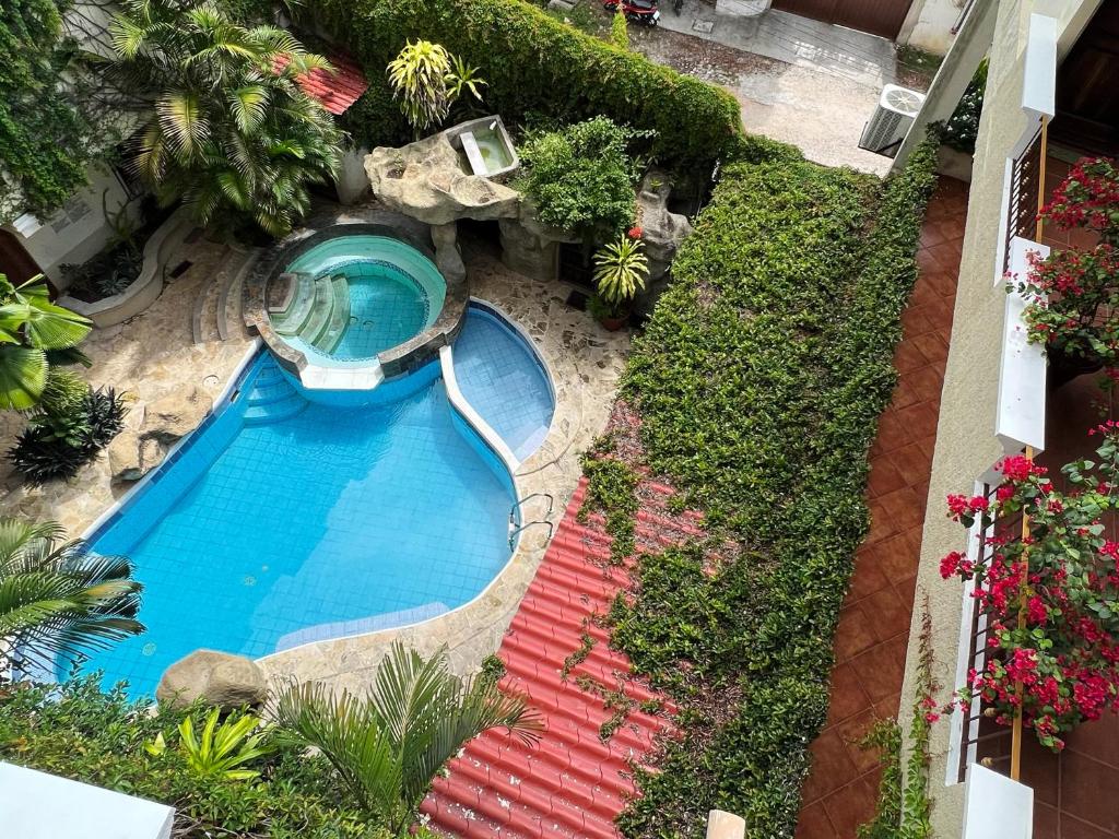 een uitzicht over het zwembad in de tuin bij Hotel Quinta Maya in Flores