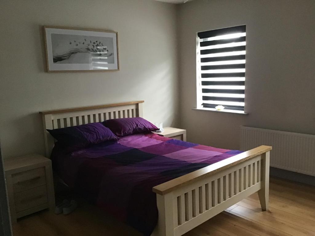 Un dormitorio con una cama con sábanas moradas y una ventana en Room to rent en Mullingar