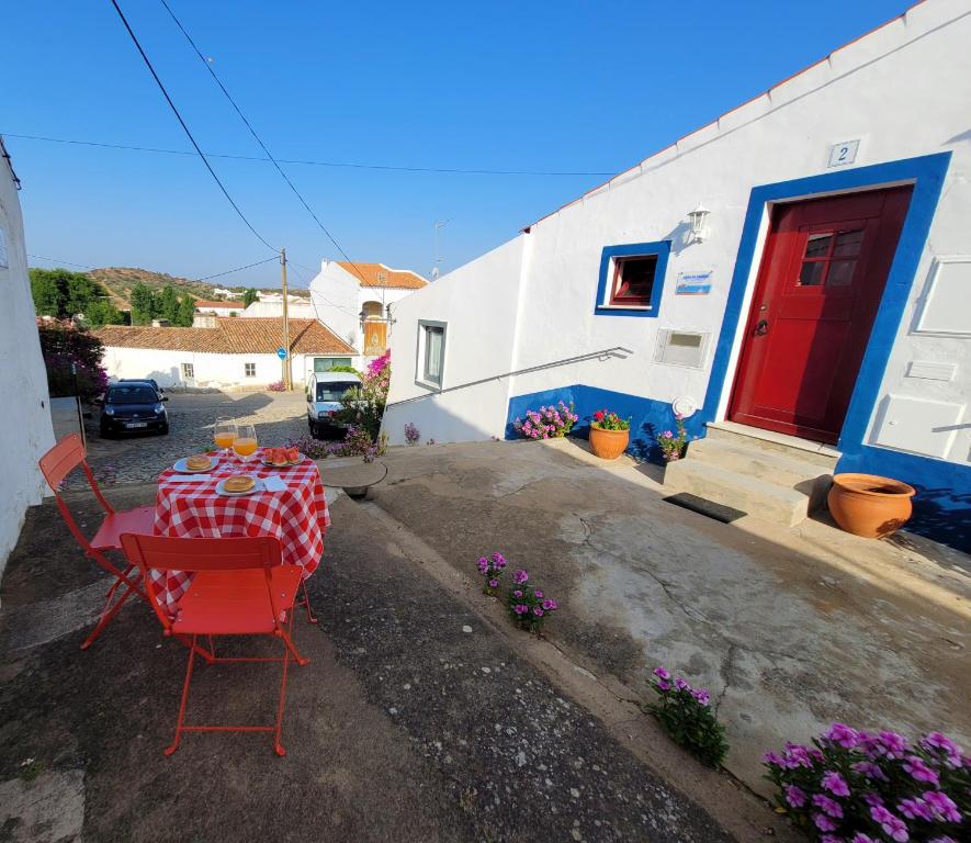 einen Tisch und Stühle in einem Hof mit einem Gebäude in der Unterkunft Casa da Chaminé - A Casa da Chaminé "torta" in Amieira