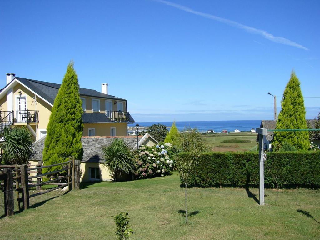 a house with a fence and trees in the yard at Casa Guillermo in Barreiros