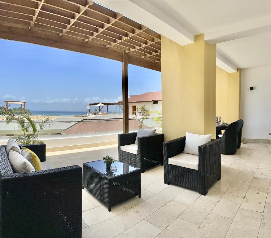 uma sala de estar com cadeiras e mesas e uma grande janela em Hacienda Samana Bay Residences em Santa Bárbara de Samaná