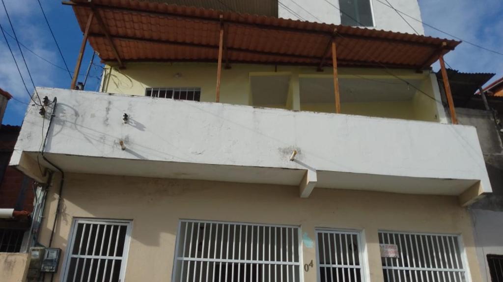 un bâtiment avec un mur blanc au-dessus dans l'établissement Casa temporada Caípe fundo, à São Francisco do Conde