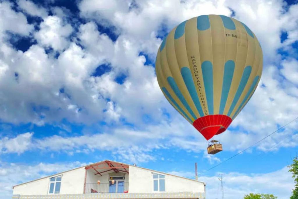 a hot air balloon flying over a building at Familiar Villae in Capadoccia Turkey in Avanos