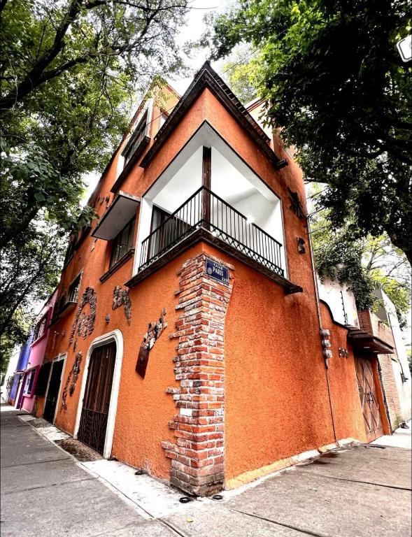 a red brick building with a balcony on a street at Casa Olivo in Mexico City