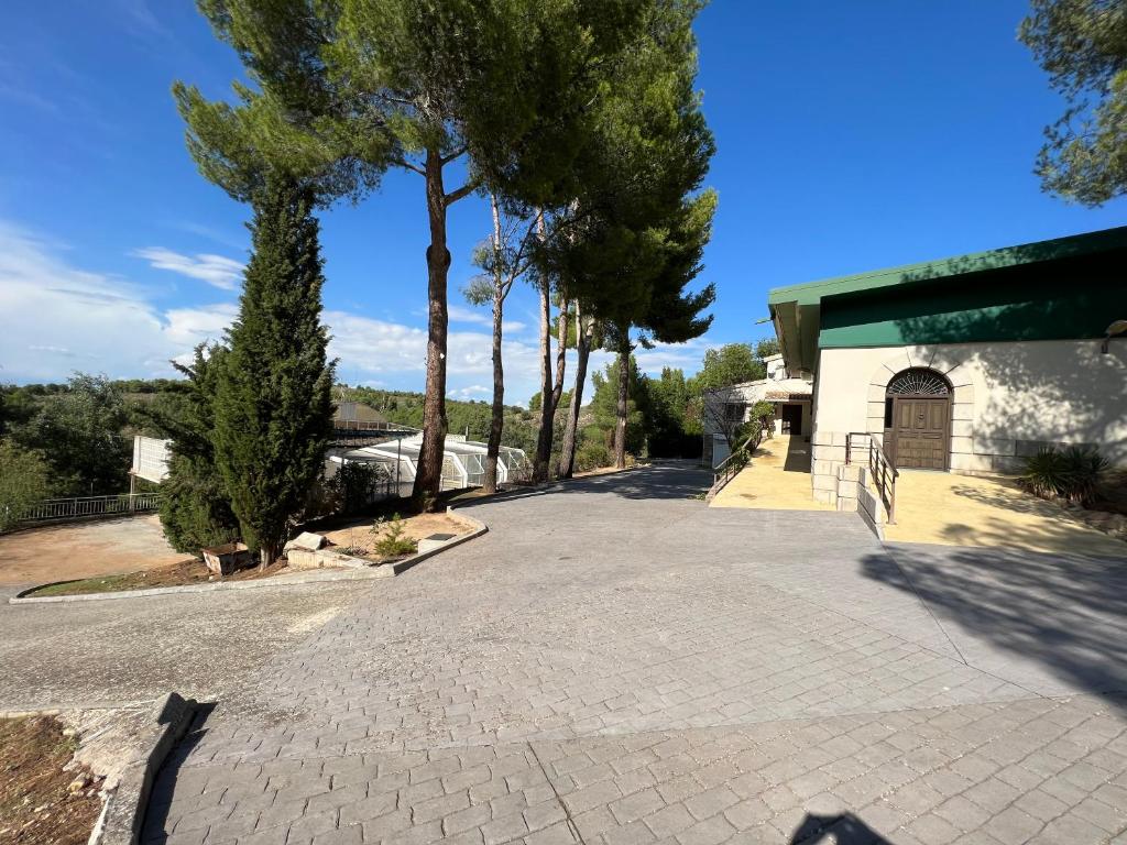 um parque de estacionamento vazio com árvores e um edifício em Luxury Villa con Piscina y Tenis em Argés
