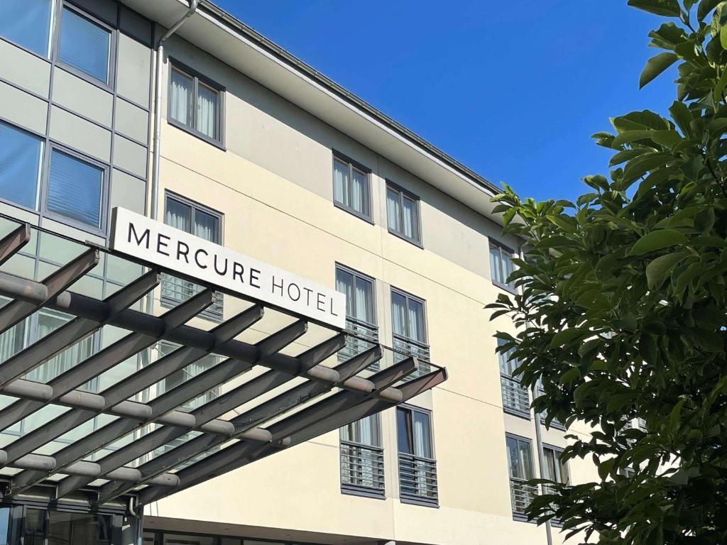 格拉的住宿－Mercure Hotel Gera City，一座建筑,上面有美化酒店的标志