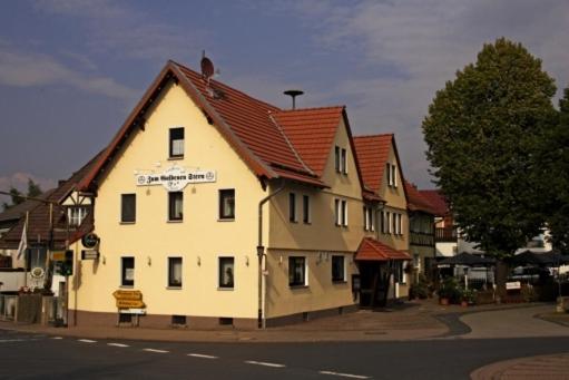 ein großes weißes Gebäude mit rotem Dach in der Unterkunft Hotel-Restaurant Zum Goldenen Stern in Großalmerode