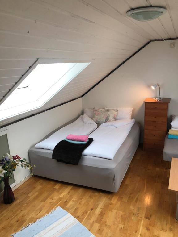 a bedroom with a bed in a attic with a window at King size bed, hjem med utsikt, gratis parkering in Bodø