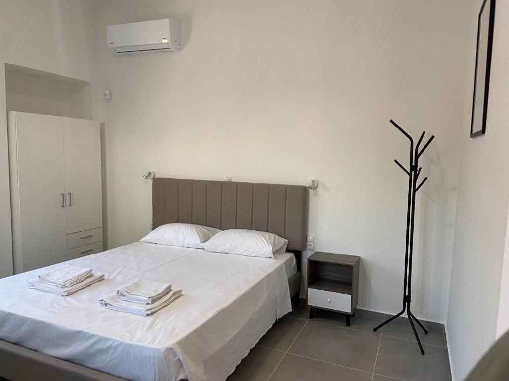 a bedroom with a large white bed and a tv at Leo's Apartments in Koropi