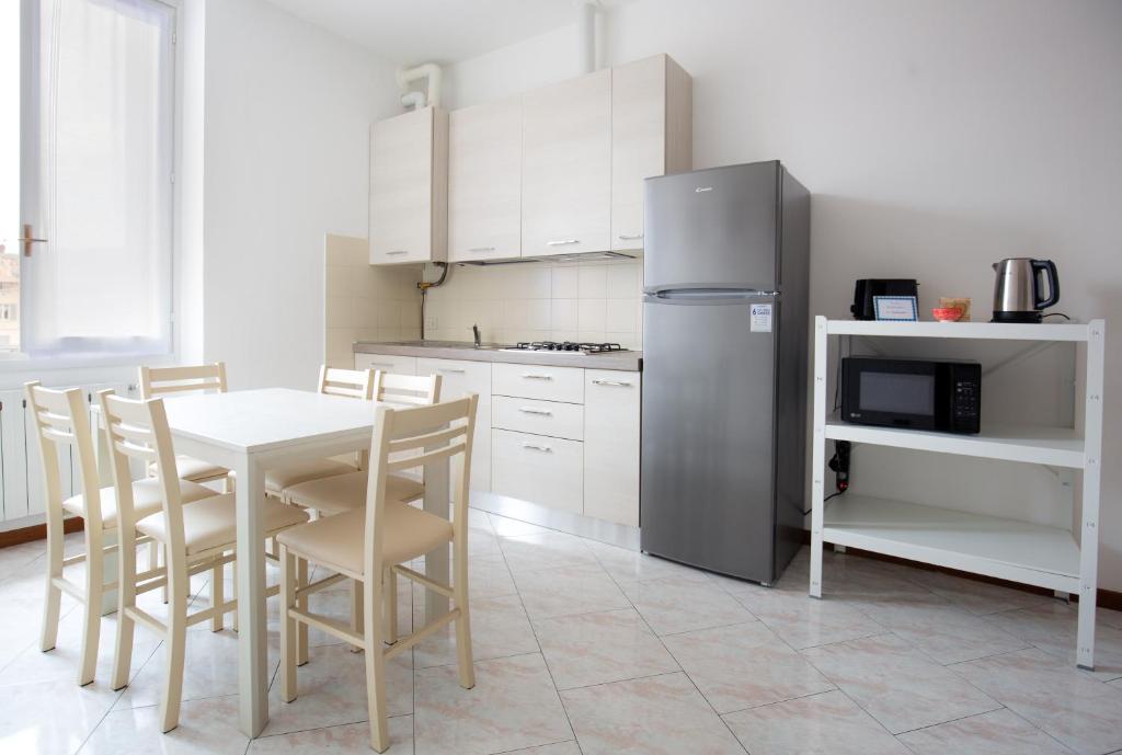 a kitchen with a table and chairs and a refrigerator at Carola's place - by Relais Di Giada in Como