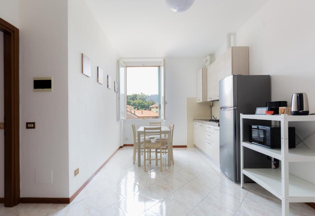 a kitchen with a refrigerator and a table with chairs at Carola's place - by Relais Di Giada in Como