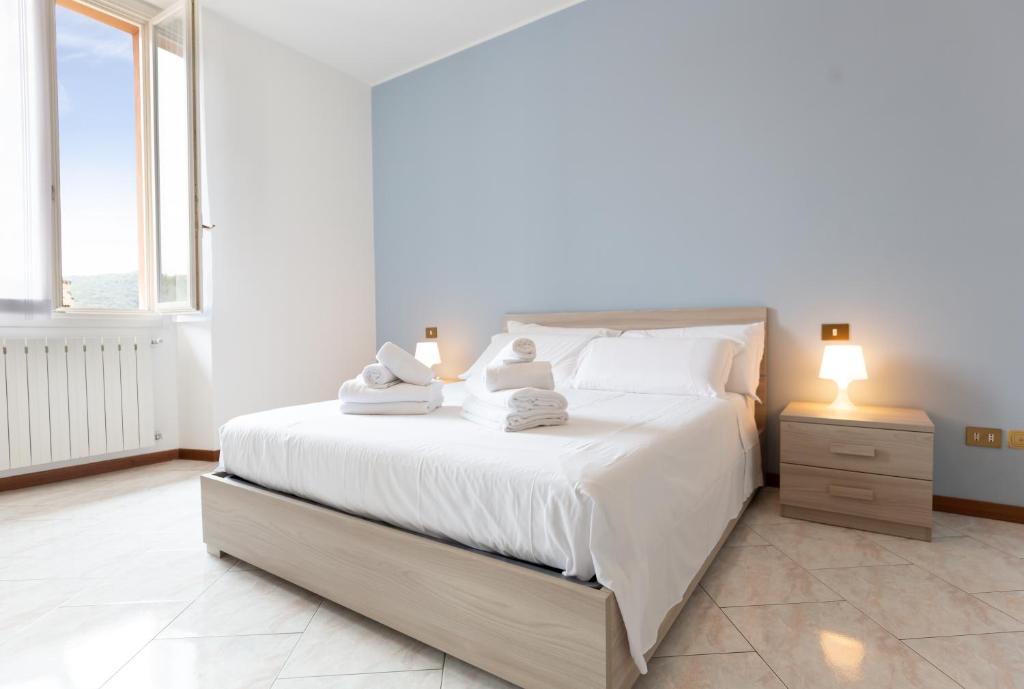 a bedroom with a white bed with towels on it at Carola's place - by Relais Di Giada in Como