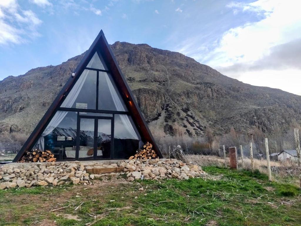 a frame house with a window in front of a mountain at Loft de Montaña Único y Moderno in Esquel