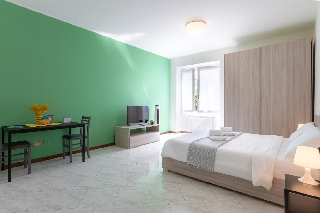 a bedroom with a bed and a desk and a television at Carola's place - by Relais Di Giada in Como