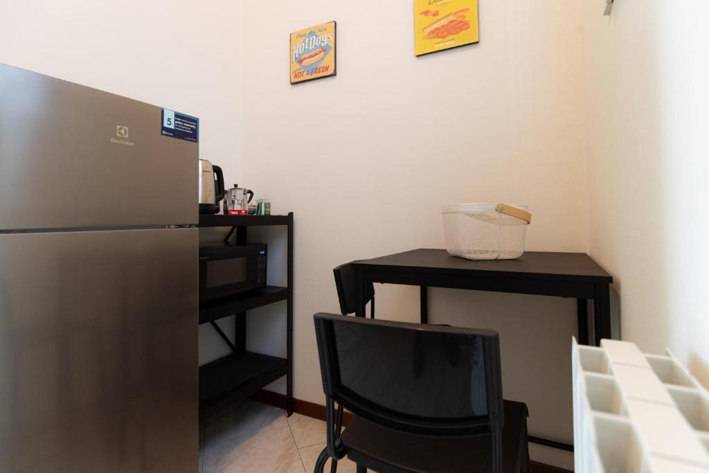 a kitchen with a refrigerator and a table and a chair at Carola's place - by Relais Di Giada in Como