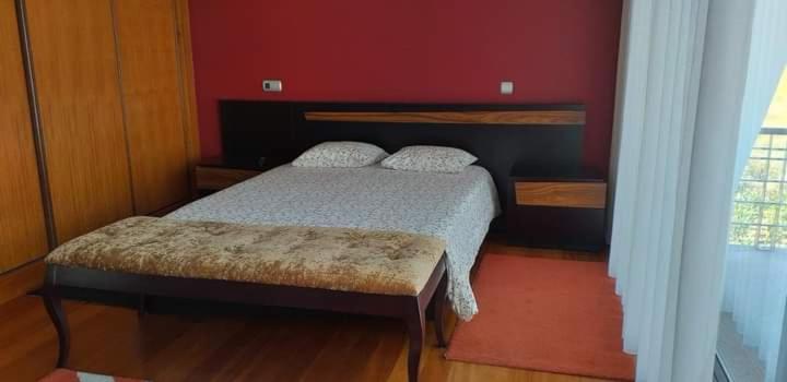 een slaapkamer met een bed en een rode muur bij Casa do Chino 