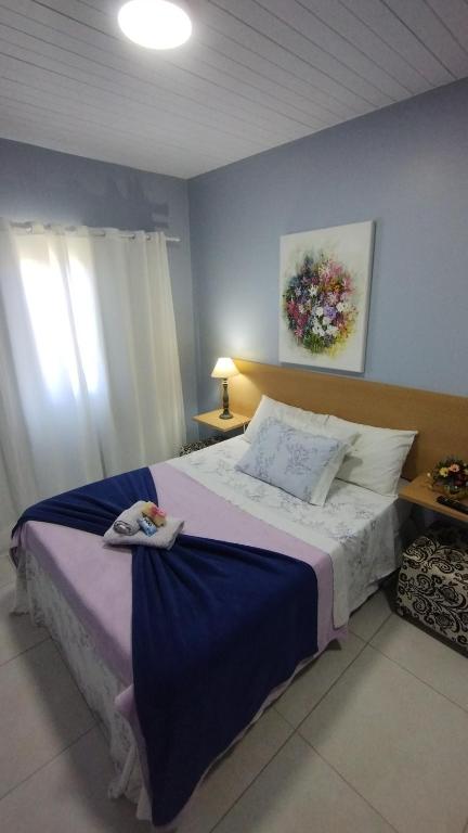 a bedroom with a large bed with blue walls at Solar da Lorena in Florianópolis