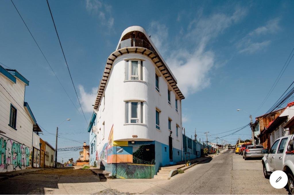 un bâtiment blanc avec un objet sur son côté dans l'établissement Hostal lala porteña vista al mar, baño privado y desayuno, à Valparaíso