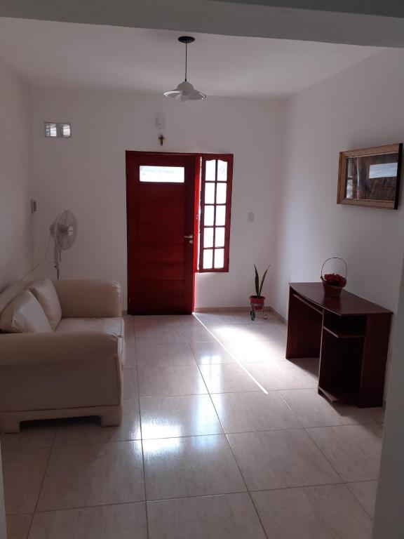 a living room with a couch and a red door at La Terrasita in Villa María