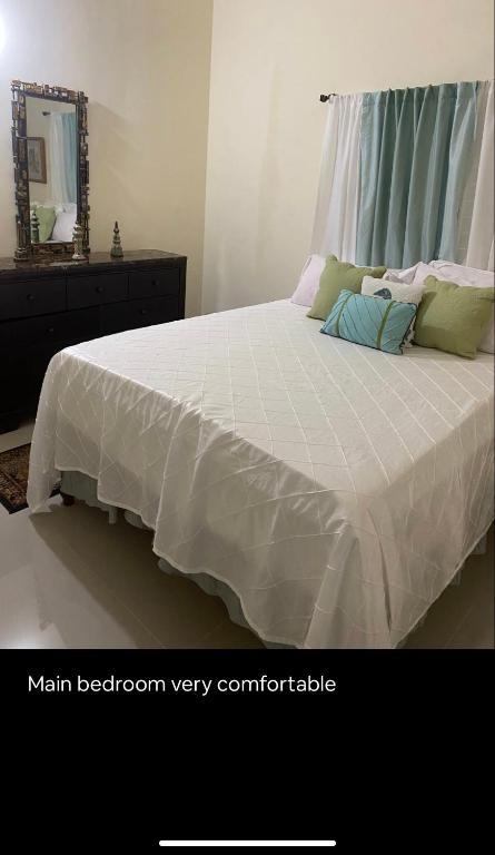 a bedroom with a large bed with a white comforter at 2 Bedroom Apt Falmouth in Florence Hall