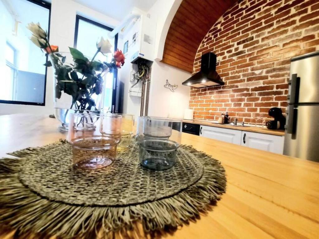 a kitchen with a table with glasses and flowers on it at Timisoara Central 2 Bedroom Hotel Serviced Belle Vue Apart By the Park in Timişoara