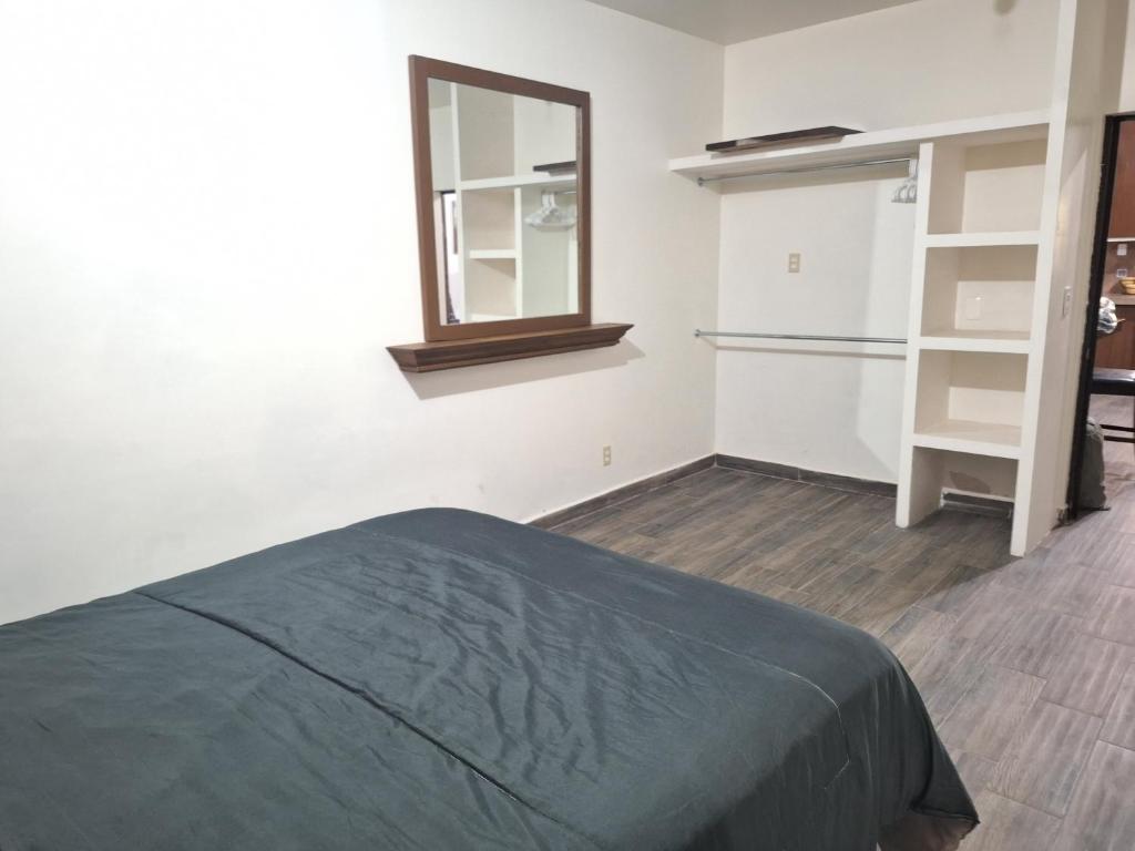 1 dormitorio con cama, espejo y armario en MercedesHouse, en Hermosillo