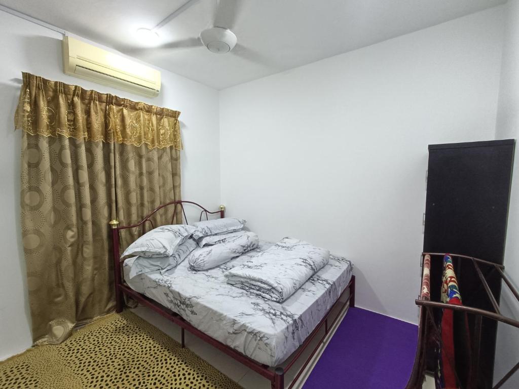 a bedroom with a bed in a room with a window at Homestay Kesang Sungai Rambai in Kampong Sungai Rambai