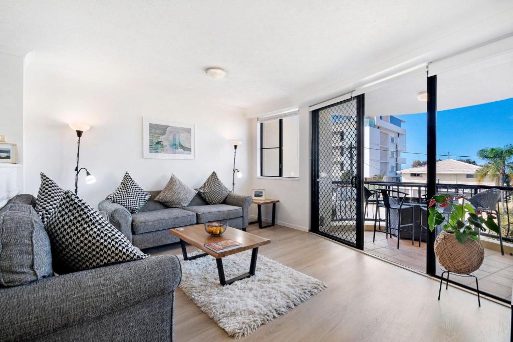 a living room with a couch and a table at Paradise Ocean 2 Bedroom Apartment in Gold Coast
