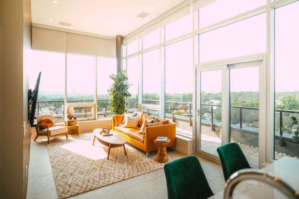 NEW Luxury 2BR Penthouse Apt In Central Halifax في هاليفاكس: غرفة معيشة مليئة بالأثاث والنوافذ الكبيرة