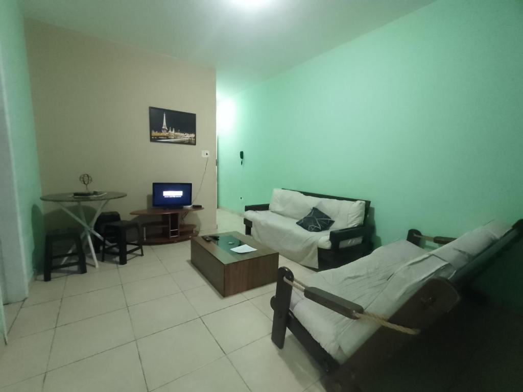 a living room with a bed and a couch at Apartamento para até 05 pessoas no centro in Teresópolis