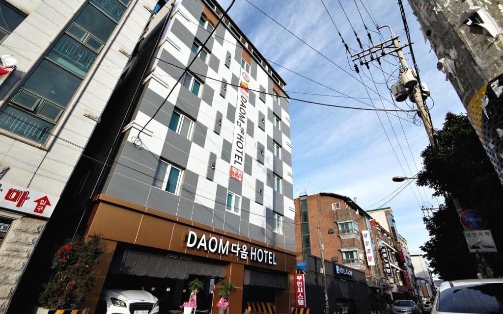 um edifício alto numa rua da cidade com em Daom motel em Jinju