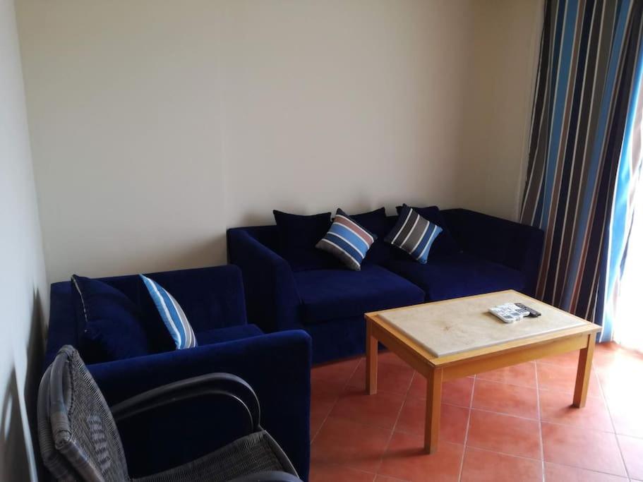 a living room with a blue couch and a coffee table at Golf Porto Marina VIP in El Alamein