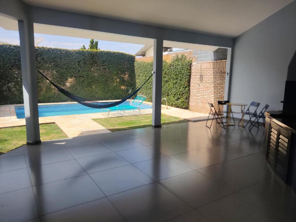 a living room with a hammock in a house at Quarto e piscina in Marechal Cândido Rondon