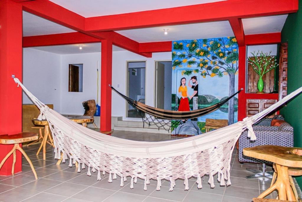a hammock in a room with a painting at Casa Cacto - Ilha do Ferro AL in Pão de Açúcar