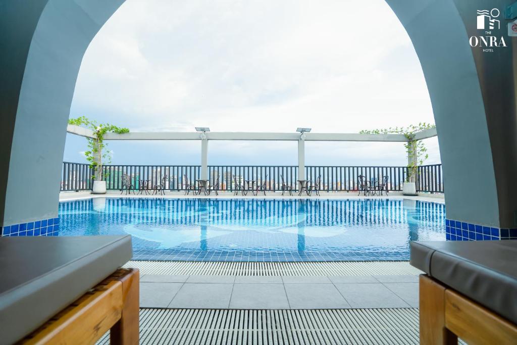 a swimming pool in a building with an arch over it at The ONRA Hotel in Phnom Penh