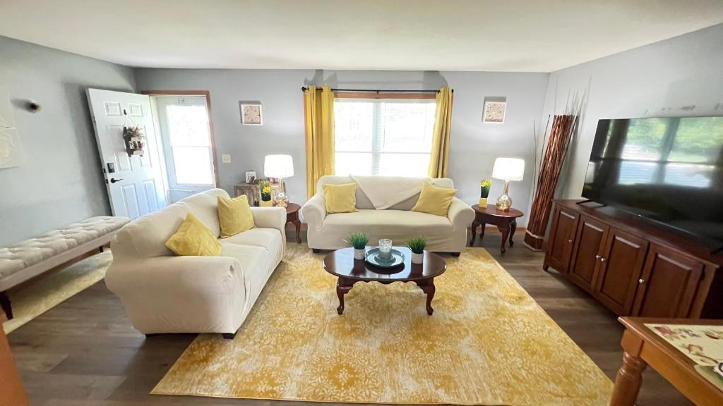 a living room with two white couches and a coffee table at Luxx Guest House in Milwaukee