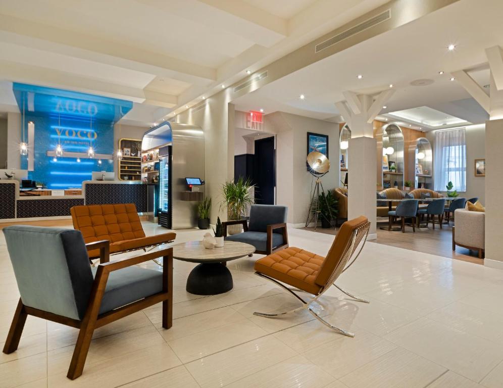a lobby of a hotel with chairs and a table at voco Fiorello - LaGuardia East, an IHG Hotel in Flushing