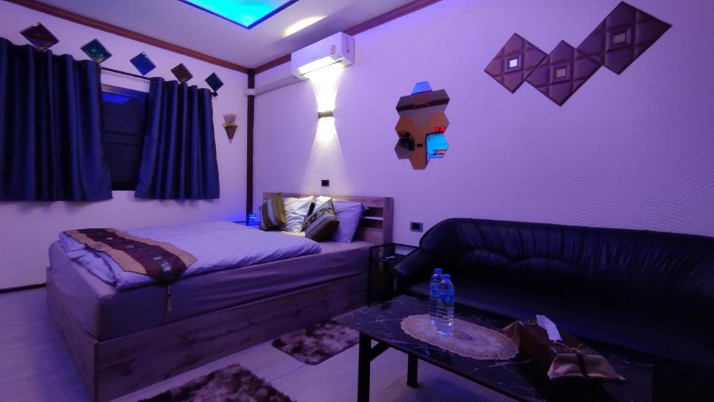 1 dormitorio con cama, sofá y mesa en Touch the Wind en Chaiyaphum