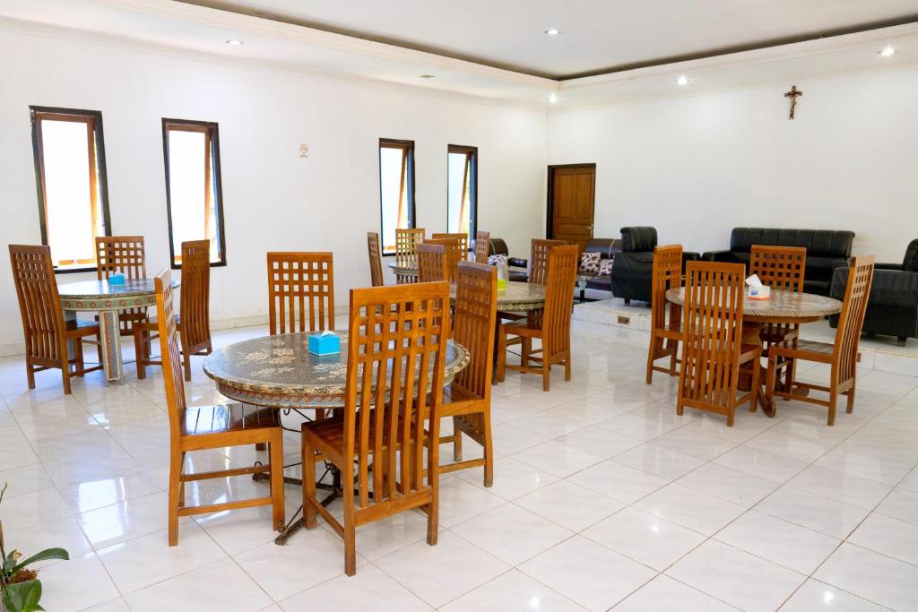 a dining room with wooden tables and chairs at Hotel Green Prundi in Labuan Bajo