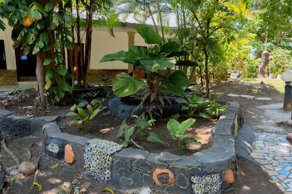a garden with rocks and plants in front of a house at Hotel Green Prundi in Labuan Bajo