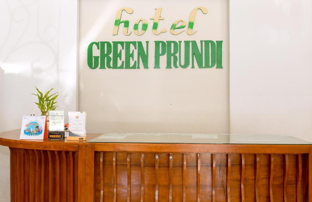 a sign for a hotel green fund on a wall at Hotel Green Prundi in Labuan Bajo