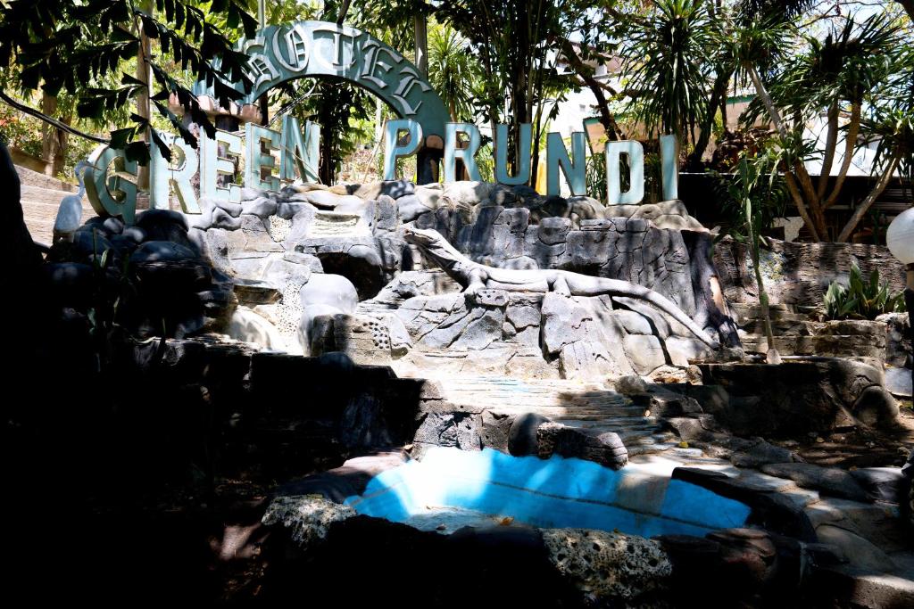 una exposición del zoológico con un cartel en el fondo en Hotel Green Prundi, en Labuan Bajo