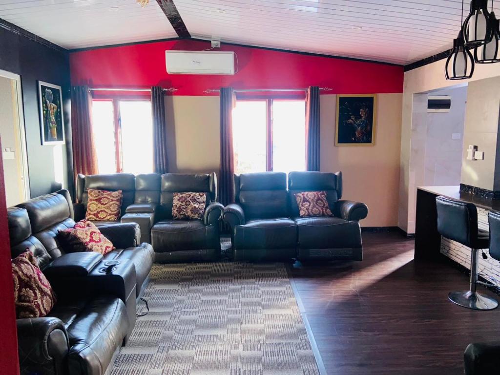 una sala de estar con muebles de cuero y paredes rojas. en Al - Minhaj Service Apartments, en Nadi