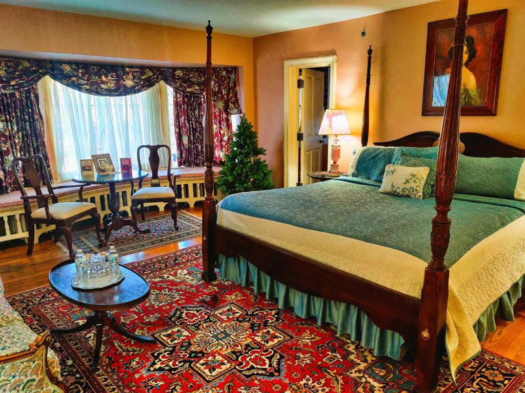 1 dormitorio con cama, mesa y escritorio en Montague Inn Bed & Breakfast en Saginaw