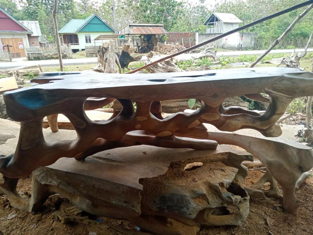 a wooden table sitting on top of a tree stump at Piut in Siluman
