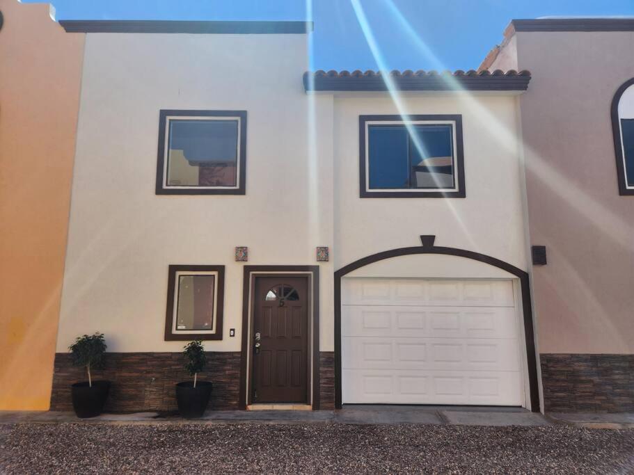 a white house with a door and a garage at 3 bedroom townhouse w garage blocks from the beach in Puerto Peñasco