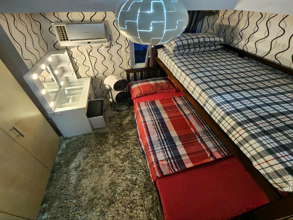 einen Blick über ein Schlafzimmer mit 2 Betten in der Unterkunft Elegant Studio at Grass Residences 1-5 persons only, Quezon City in Manila