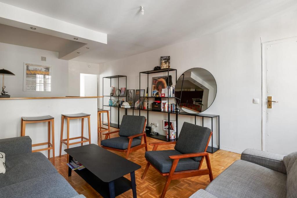 - un salon avec un canapé, des chaises et un miroir dans l'établissement Appartement Garnet - Welkeys, à Paris