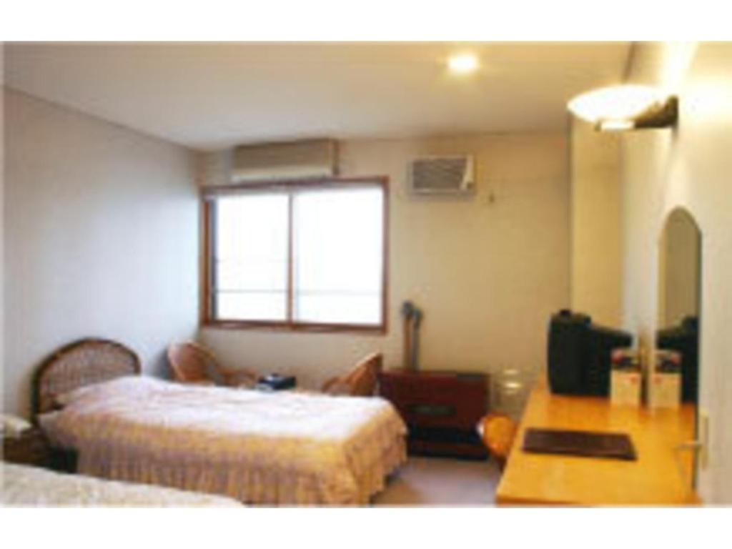 函館市にあるDaikokuya Ryokan - Vacation STAY 53558vのベッド2台、テーブル、窓が備わる客室です。