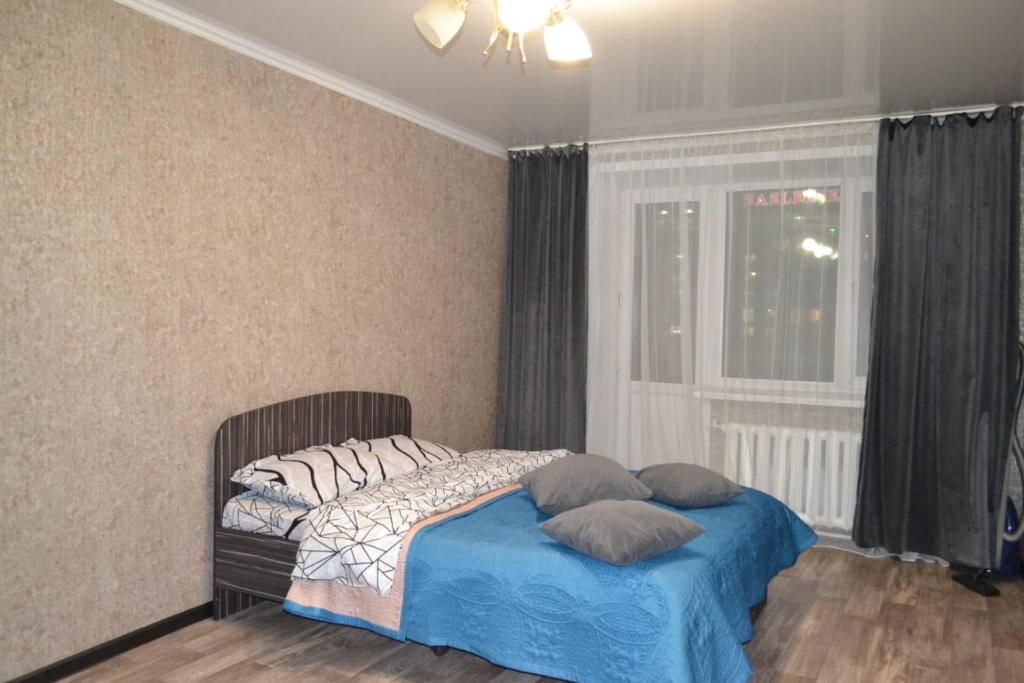 科克舍陶的住宿－Ауельбекова 53，卧室配有带枕头的床铺和窗户。